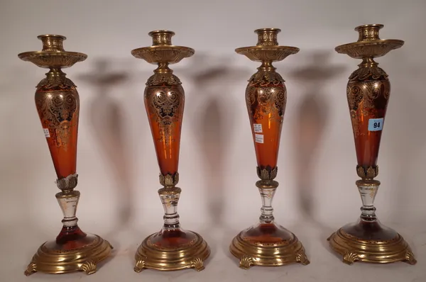 A set of four modern amber glass and gilt metal mounted candlesticks, each with gilt foliate decoration, 42.5cm high. (a.f.) (4)