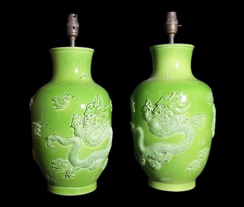 A pair of 20th century Chinese green ceramic table lamps moulded with dragons with character marks to base, 43cm high overall. (2)  Provenance; proper