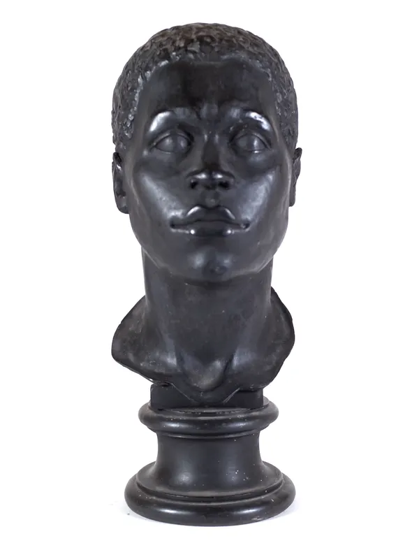 A late 19th/early 20th century black painted plaster bust of a Nubian man, on turned socle, 50cm high.  Provenance; property from the late Sir David T