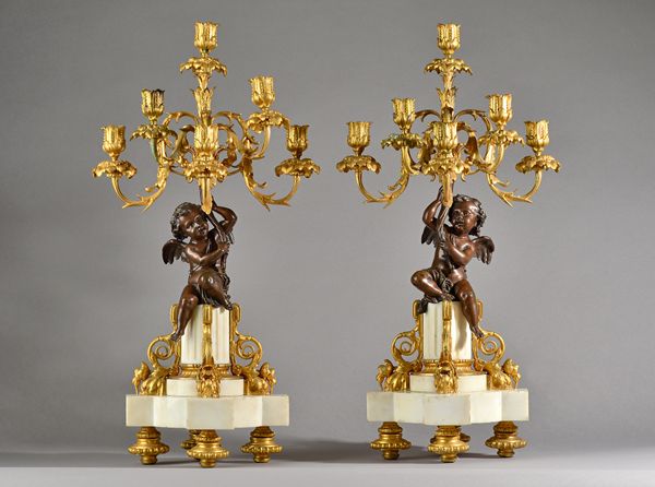 In the manner of Henry Dasson, a pair of French bronze, ormolu and white marble six branch figural candelabra, late 19th century, the central cupid fi