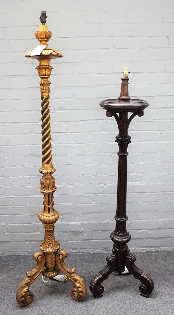 An 18th century style giltwood standard lamp, Italian manner, carved with acanthus on three shaped legs (160cm high) and a carved oak standard lamp, (