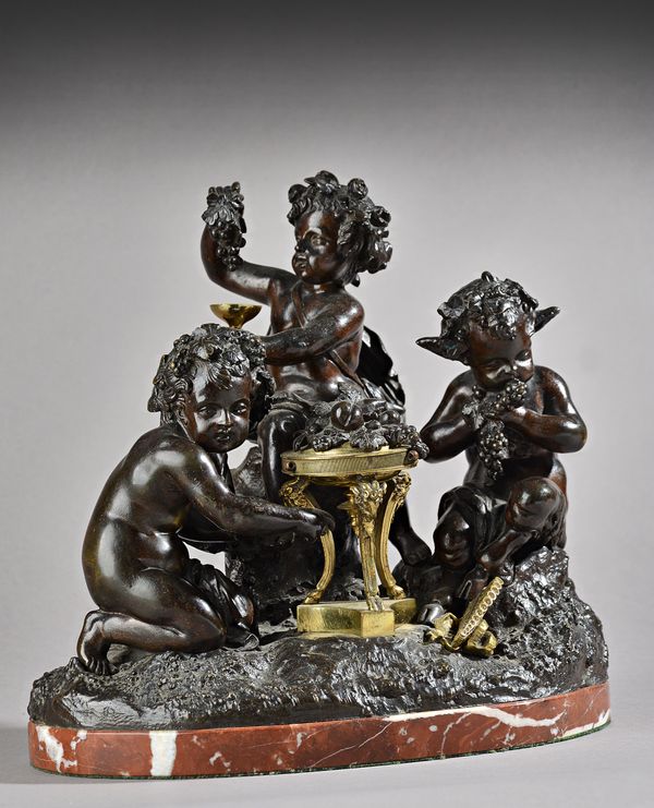 In the manner of Clodion, a French bronze figure group, late 19th century, depicting two Putto and a Satyr with grape vines and piccolo on a naturisti