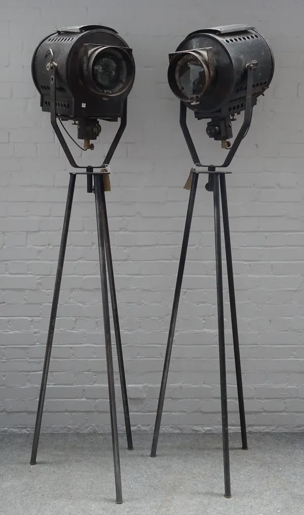 A pair of ebonised metal studio lights, circa 1950, each raised on a later metal tripod base. 205cm overall. (2)