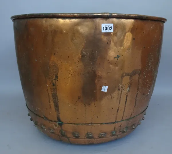 A Victorian copper log bin with rivetted seams, 61cm diameter and two Persian circular copper trays with engraved decoration, the largest 77cm diamete