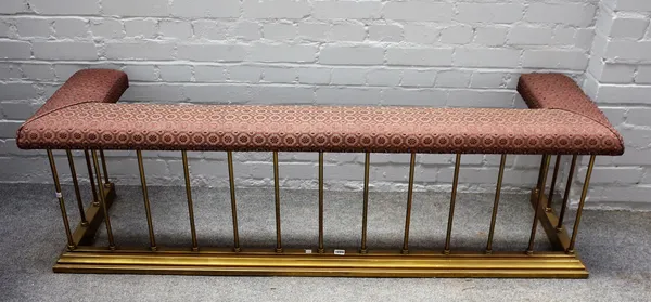 A modern brass club fender with upholstered seat over pillared supports and a stepped kerb, 168cm wide.