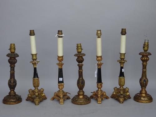 A pair of modern gilt metal table lamps of 18th century candlestick style, raised on a triform base, 28cm high, a similar smaller pair and a set of th