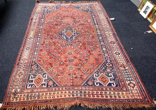 A Ghashgai carpet, South Persian, the floral madder field with a hooked central medallion, four matching spandrels, an ivory plant border, 283cm x 170