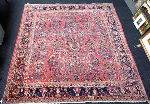 A Sarough carpet, Persian, the pink field with vases of abundantly floral sprays, other floral sprays, an indigo palmette and floral vine border, (red