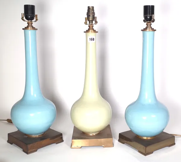 A pair of duck egg blue porcelain bottle neck vases converted to table lamps, each on a brass plinth, 44cm high and a similar yellow ground table lamp