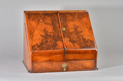 A Victorian figured walnut slope front stationery box with calendar and fitted interior, 40cm wide x 32cm high.