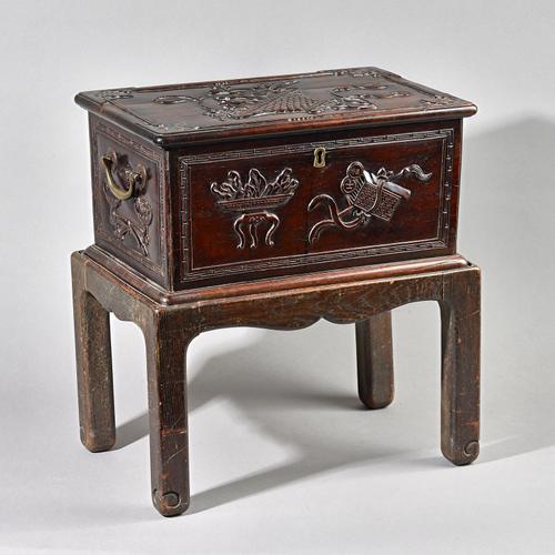 A 19th century Chinese hardwood box on stand, relief carved with 'Hundred Antiques' design, on English stand, 43cm wide x 46cm high.