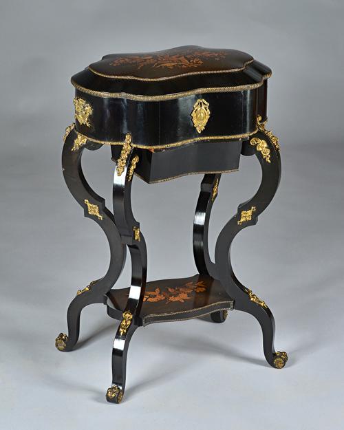 A late 19th century French floral marquetry inlaid ebonised lady's dressing table, the domed serpentine top revealing a fitted interior on shaped supp