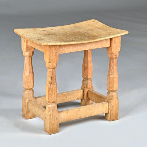 A Robert 'Mouseman' Thompson oak stool with adze top, on octagonal baluster supports, 40cm wide x 38cm high.