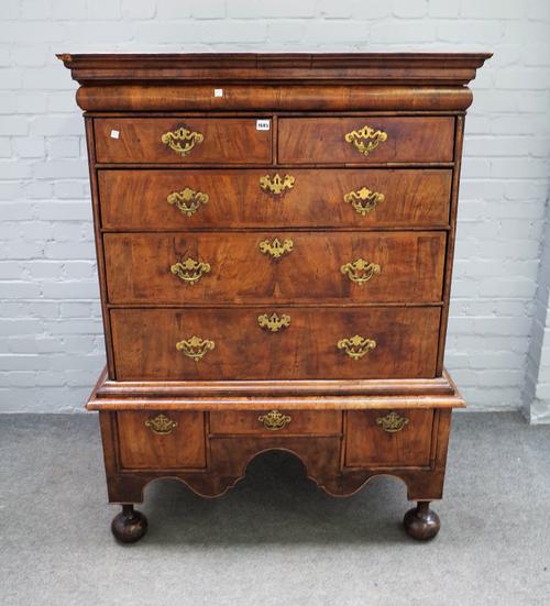 An early 18th century figured walnut chest on stand, with one long cushion drawer over two short and three long graduated drawers, the base with three