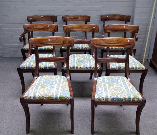 A set of eight late Regency mahogany bar back dining chairs on sabre supports to include a pair of carvers, (8).