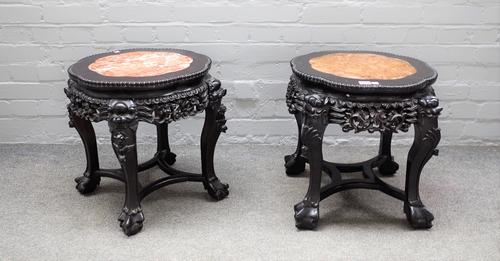 A near pair of early 20th century Chinese carved jardiniere stands with inset marble tops on paw feet, 50cm wide x 46cm high, (2).