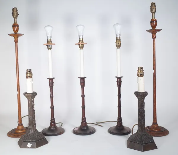 A set of three modern mahogany candlestick table lamps of turned form, 32cm high, a similar taller pair with square pleated shades and a pair of spelt