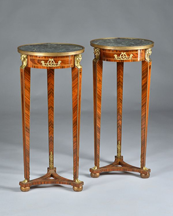 A pair of Empire Revival torchere stands, each with circular marble tops on a trio of gilt metal mounted kingwood caryatid supports, 40cm diameter x 8