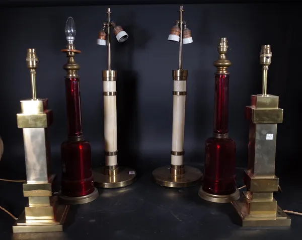 A pair of ruby red glass table lamps of faceted form, each on a circular brass base, 47cm high, a pair of leather bound gilt metal table lamps and a g