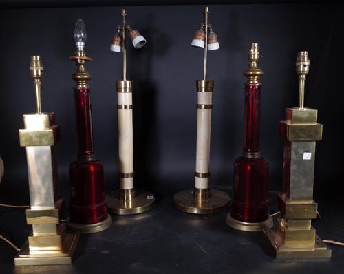 A pair of ruby red glass table lamps of faceted form, each on a circular brass base, 47cm high, a pair of leather bound gilt metal table lamps and a g