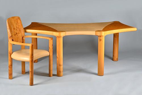 John Makepeace, a burr elm desk of shaped outline with leather inset top on turned supports, inscribed to underside 'Designed by John Makepeace and ma