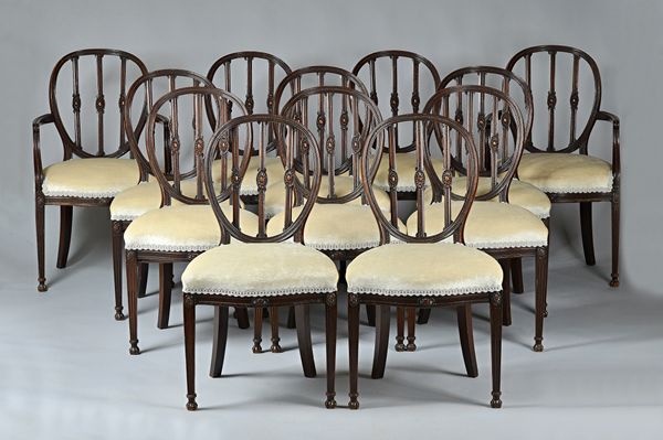 A set of  twelve George III style mahogany framed dining chairs, the oval back with triple patera splat over serpentine seat, on channelled square sup