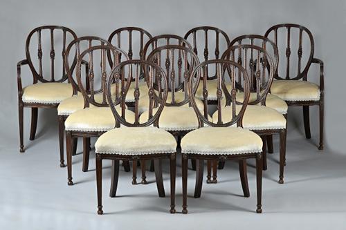 A set of  twelve George III style mahogany framed dining chairs, the oval back with triple patera splat over serpentine seat, on channelled square sup