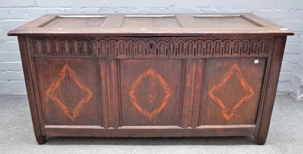 A 17th century inlaid oak coffer with triple panel lid and front on stile feet, 137cm wide x 66cm high.