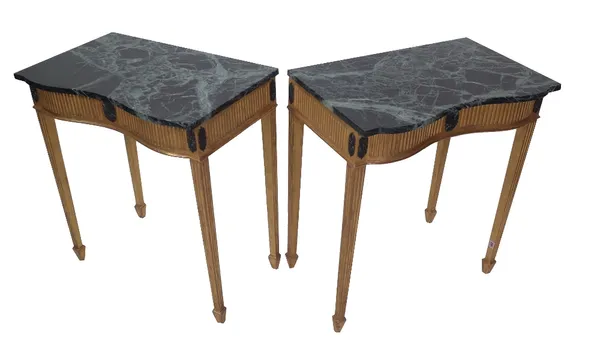 A pair of Louis XVI style giltwood marble console tables, of serpentine outline, black marble tops on fluted tapering supports, 70cm wide x 78.5cm hig