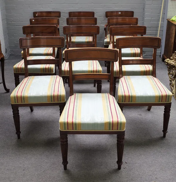 A set of twelve Regency mahogany bar back dining chairs on tapering reeded supports to include a pair of carvers, (12).