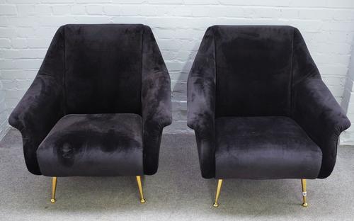 A pair of retro design black upholstered easy armchairs, on turned lacquered brass supports, 82cm wide x 90cm high, (2).