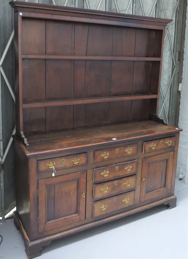 An 18th century oak dresser, the enclosed two tier plate rack over six drawers and pair of cupboards on bracket feet, 160cm wide x 190cm high.