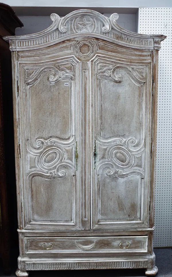 A 19th century limed oak armoire, with pair of shaped double panel doors, over single drawer, on splayed canted bracket feet, 135cm wide x 229cm high.