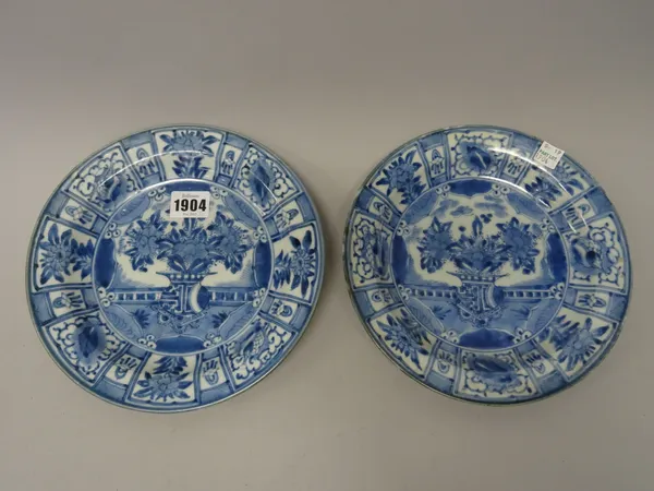 A pair of Japanese blue and white plates, Edo period, early 18th century, each painted in the centre with a vase of flowers inside a panelled border,(