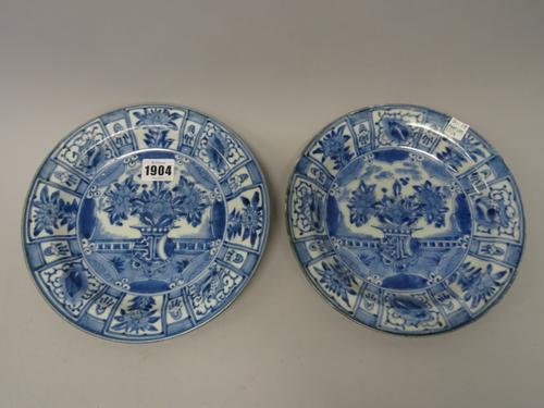 A pair of Japanese blue and white plates, Edo period, early 18th century, each painted in the centre with a vase of flowers inside a panelled border,(