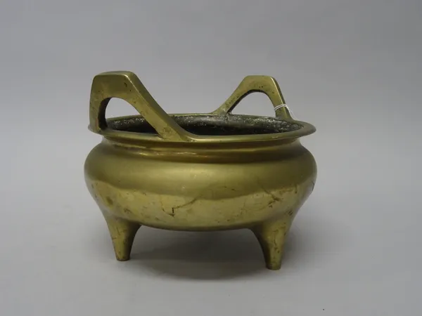 A Chinese bronze censer, six character Xuande mark but later, set with upright handles and raised on three peg supports, 22.5cm. wide across handles.