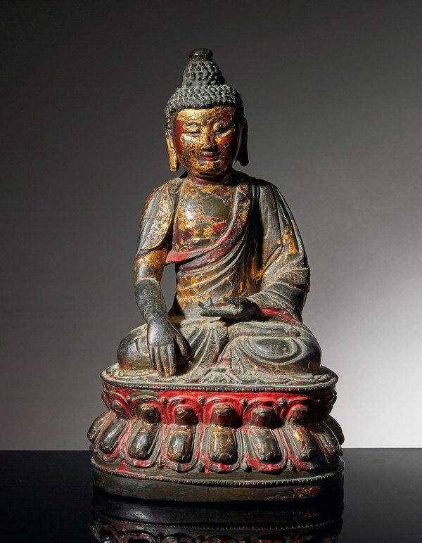 A gilt bronze figure of Buddha, Ming dynasty, cast seated on a double lotus base. with right hand reaching down in bhumisparsa mudra, the left hand in