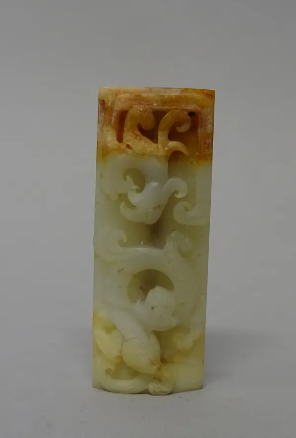 A Chinese jade rectangular bead, probably Han dynasty, carved with a dragon and phoenix, the reverse carved with scrolls, the stone of celadon, cream