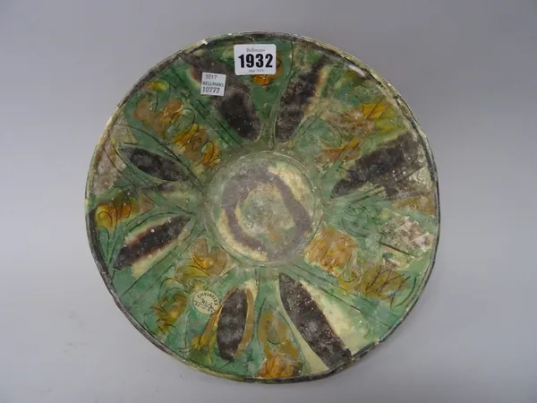 A Nishapur pottery sgraffito bowl, 12th century, decorated with radiating panels washed in green, ochre and manganese, (a.f), 24cm. diameter. Christie