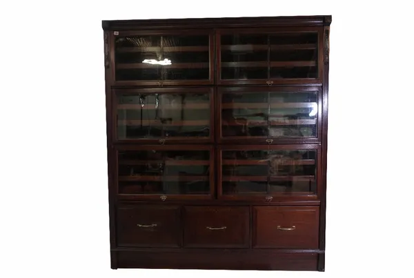 A pair of 20th century mahogany haberdashery cabinets, each with six glazed door enclosing six pull out trays above three lower drawers, 157cm wide x