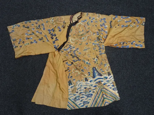 A Chinese embroidered silk dragon robe, late 19th/early 20th century, the golden ground worked with dragons amongst cloud scrolls and auspicious objec