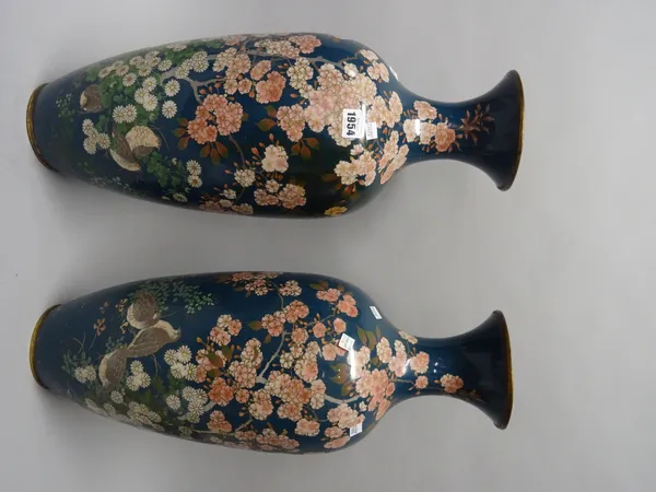 A large pair of Japanese cloisonné vases, Meiji period, each worked with birds beneath flowering shrubs against a greenish blue ground, (a.f), 61cm. h