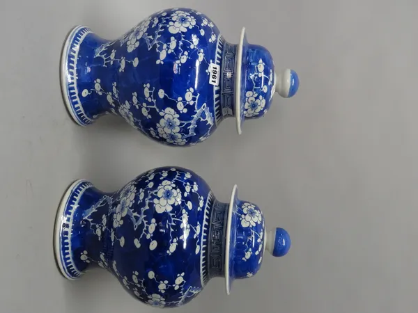 A pair of Chinese blue and white baluster vases and covers, circa 1900, each painted with branches of prunus on a `cracked ice' ground, blue four char