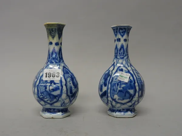 A pair of small Chinese blue and white bottle vases, Kangxi, of hexagonal form, each painted with panels of figures and vases of flowers inside barbed