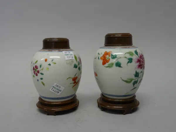 A pair of small Chinese famille-rose oviform vases, Qianlong, each painted with flowers issuing from blue rocks, 11cm. high, later wood covers and sta