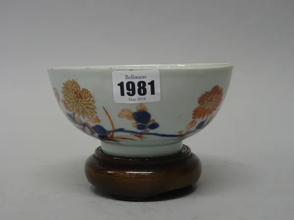 A Chinese Imari small bowl, circa 1720-50, painted with flowers in a fenced garden, 14.75cm. diameter,S.Marchant & Son paper label to base, later wood