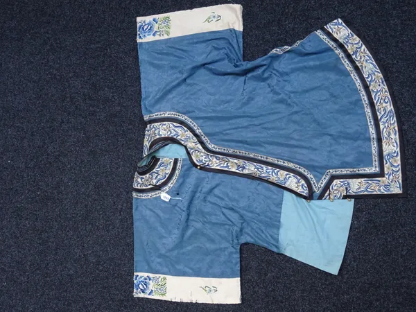 A Chinese informal jacket, late 19th/early 20th century, the blue silk ground with repeated floral design, the borders and sleeves embroidered with fl