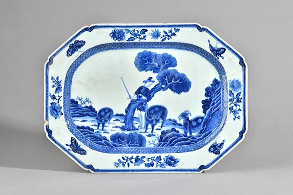 A Chinese export blue and white part service, early 19th century, painted in the centre with a goatherd and three goats in a landscape, inside a diape