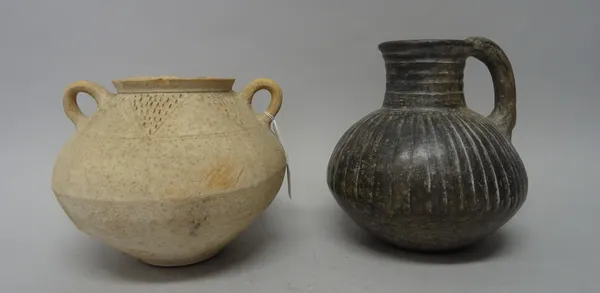 Two pottery vessels, comprising; a two-handled bulbous jar with a border of incised stylised triangular motifs, 18cm. high; and a burnished grey ewer,