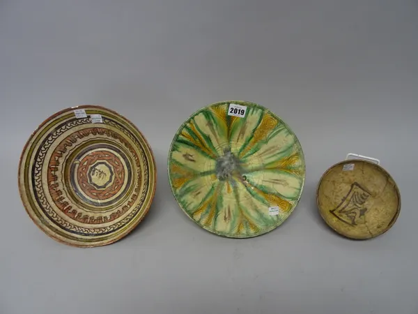 Three Nishapur pottery bowls, Persia, 10th/11th century, one with sgraffito and splashware decoration, the other two painted with brown and red slip,